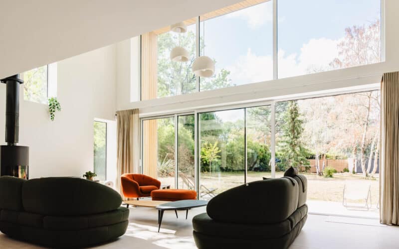 Extension moderne avec grande baie vitrée aluminium blanche donnant sur le jardin à Carquefou